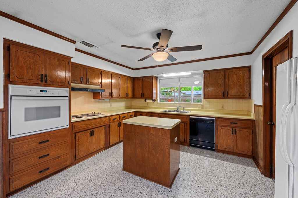 133 Oak Way Kerrville, TX 78028 - Photo 9 of 26 a kitchen with stainless steel appliances granite countertop wooden cabinets a sink a stove a refrigerator and island with wooden cabinets