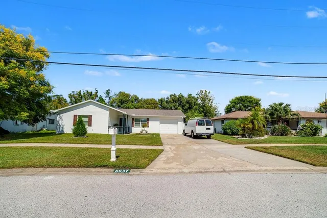 a view of a house with a yard and potted plants