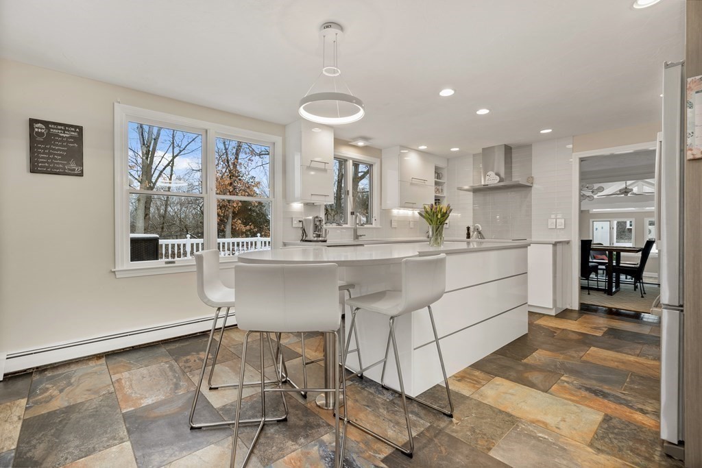 100 Manatee Road Hingham, MA 02043 - Photo 11 of 38 a kitchen with a dining table chairs cabinets and stainless steel appliances