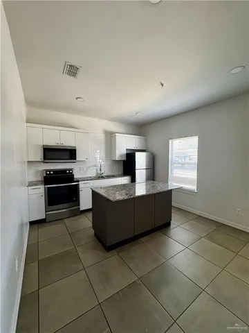 a large kitchen with a stove a refrigerator and a sink