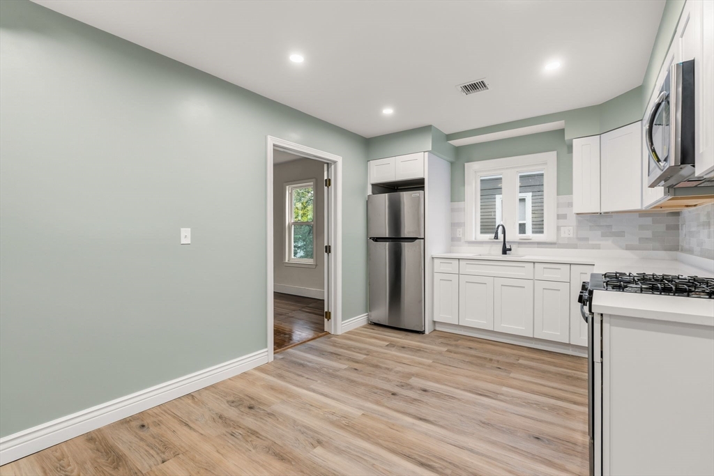 8 1/2 Intervale Street, Unit 10 1/2 Quincy, MA 02169 - Photo 4 of 16 a kitchen with stainless steel appliances granite countertop a refrigerator and a stove top oven