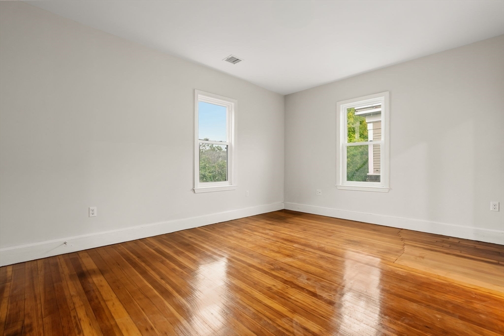 8 1/2 Intervale Street, Unit 10 1/2 Quincy, MA 02169 - Photo 8 of 16 a view of an empty room with wooden floor and a window