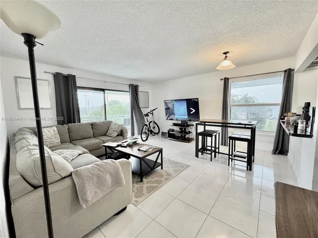 a kitchen with granite countertop a stove a sink dishwasher and white cabinets with wooden floor