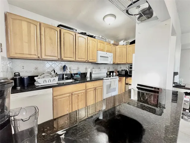 a kitchen with white cabinets and appliances