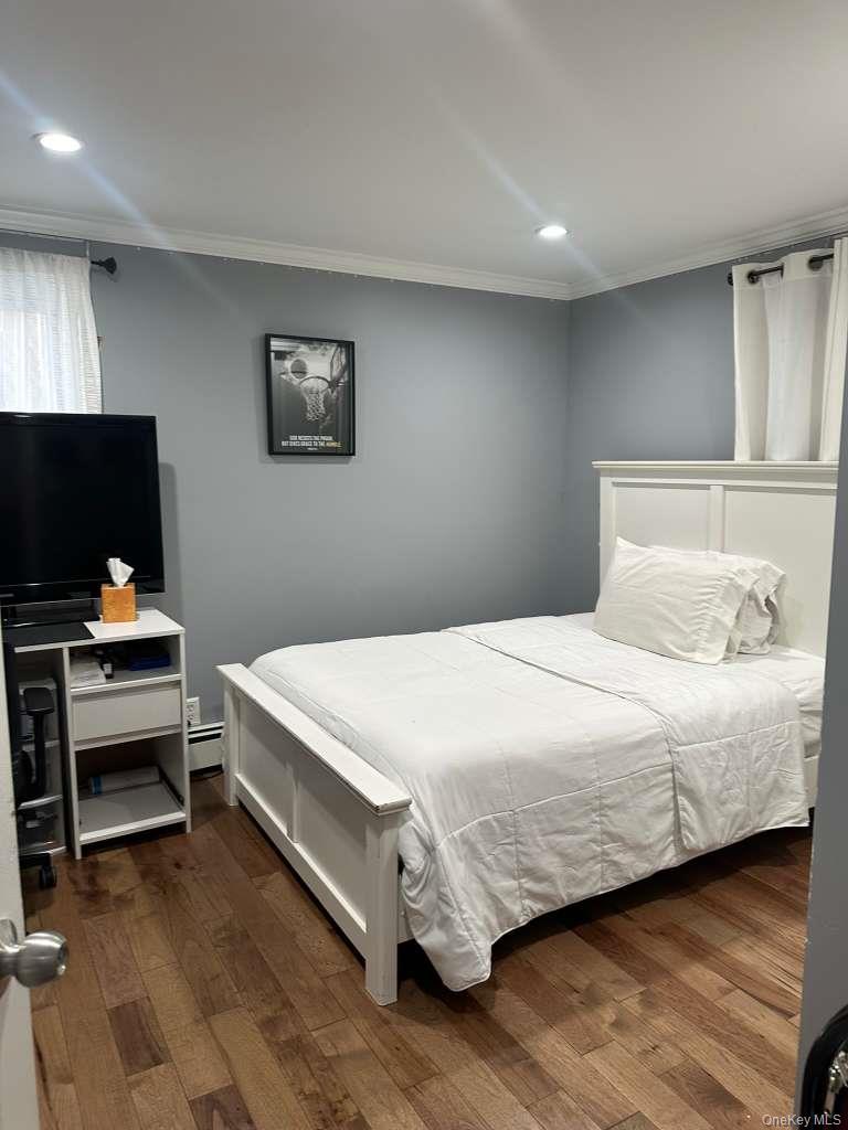 2 Ritter Avenue Amityville, NY 11701 - Photo 17 of 26 a bedroom with a bed and a flat screen tv