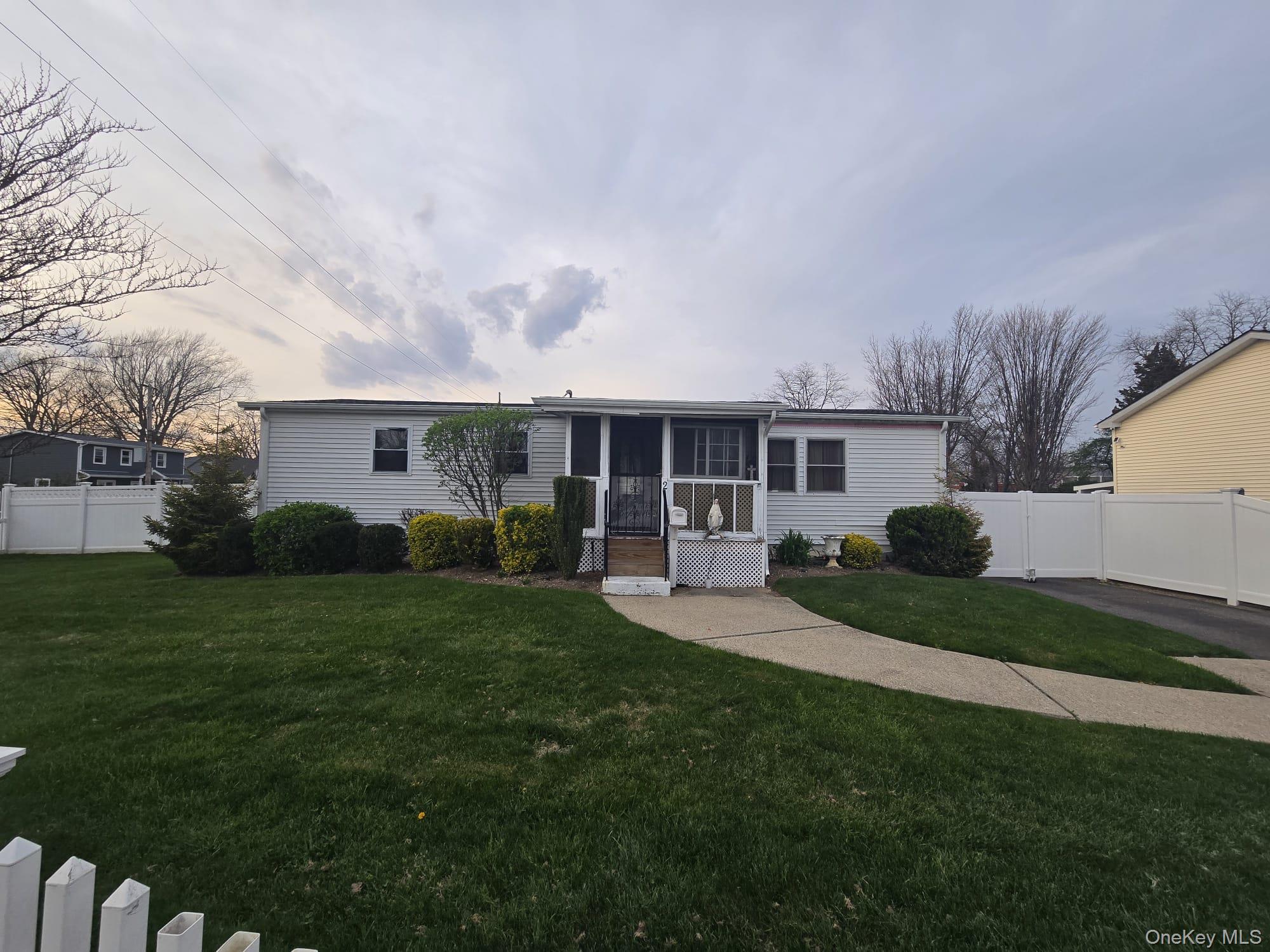 2 Ritter Avenue Amityville, NY 11701 - Photo 2 of 26 a front view of a house with a garden and yard