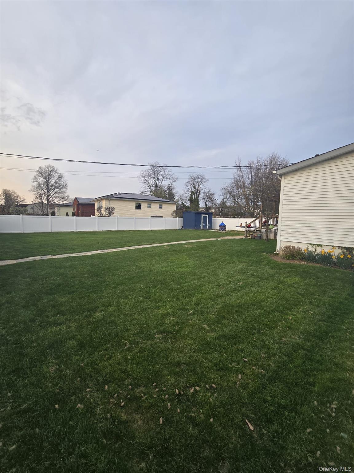 2 Ritter Avenue Amityville, NY 11701 - Photo 4 of 26 a view of a field with lawn chairs and large trees