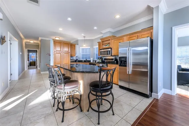 a kitchen with stainless steel appliances granite countertop a refrigerator and a stove top oven