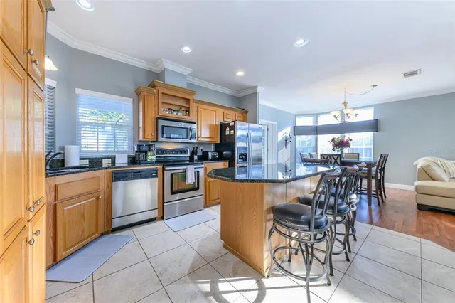 a kitchen with stainless steel appliances granite countertop a refrigerator a stove and a sink