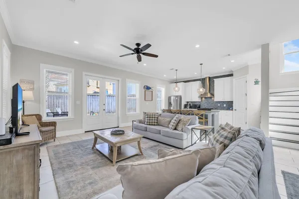 a living room with furniture kitchen view and a window