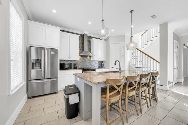 a kitchen with stainless steel appliances kitchen island granite countertop a sink and a refrigerator