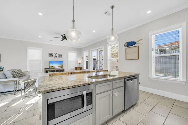 a kitchen with granite countertop a sink stove and cabinets