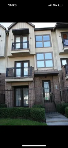 a view of brick building with many windows and a yard