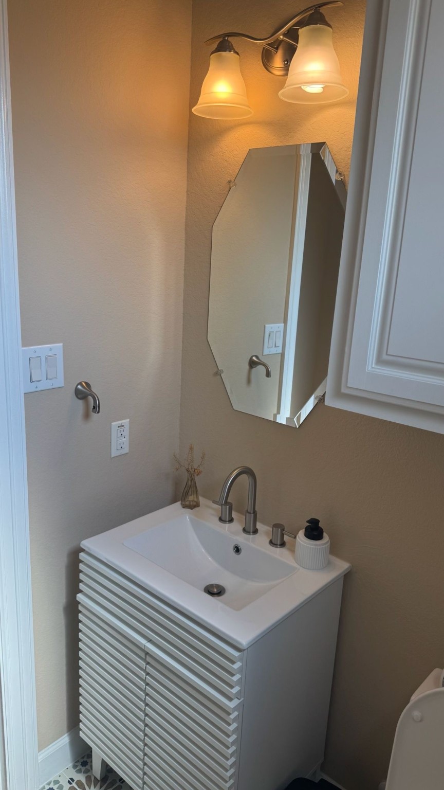 2814 Polk Street Houston, TX 77003 - Photo 7 of 9 a bathroom with a sink a toilet and mirror