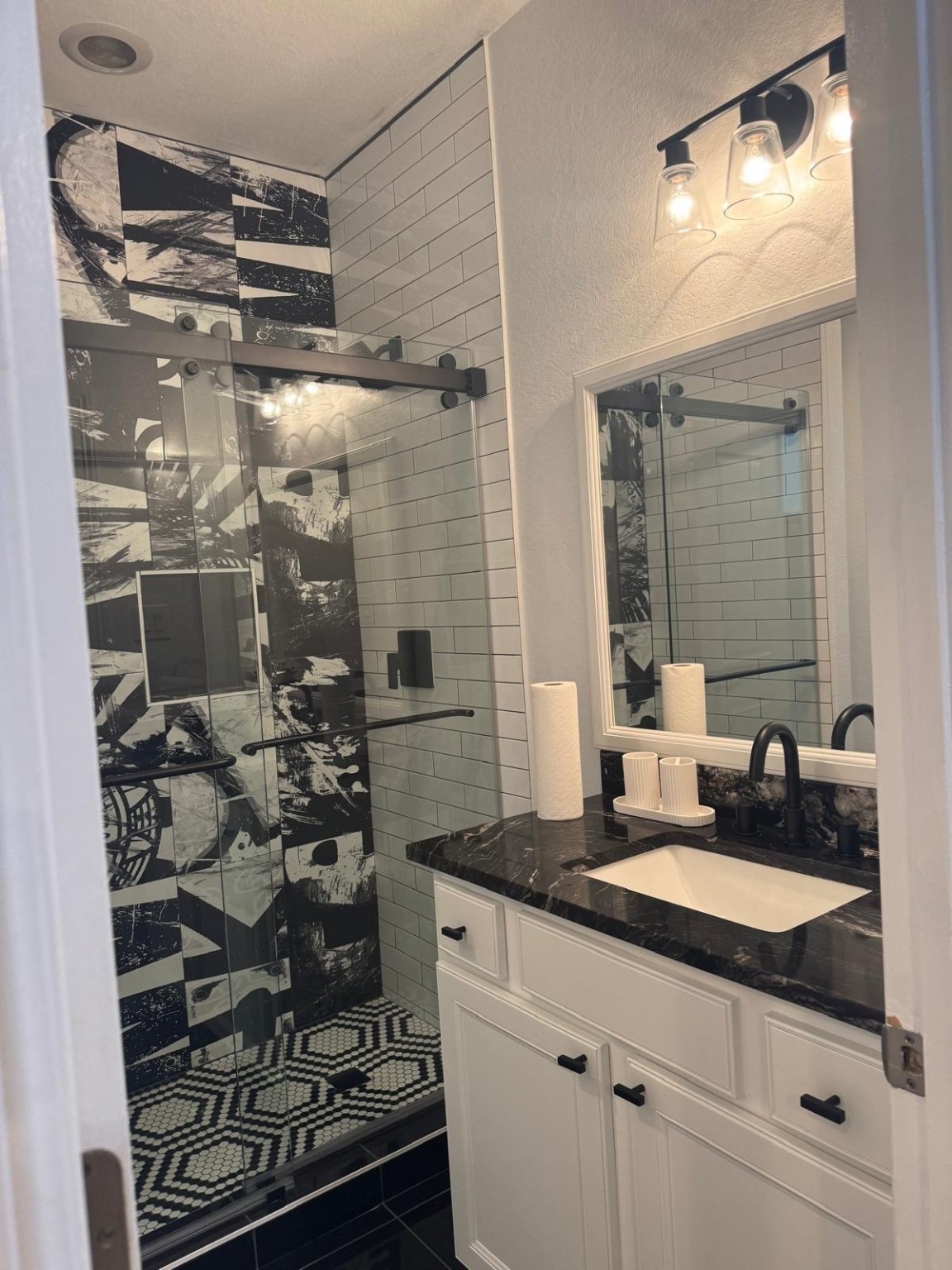 2814 Polk Street Houston, TX 77003 - Photo 8 of 9 a bathroom with a granite countertop sink a mirror and shower