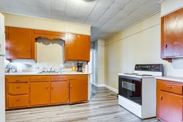 58 Johnson Street Springfield, MA 01108 - Photo 15 of 34 a kitchen with a stove a sink and wooden floor