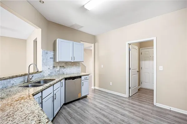 a kitchen with a sink and a wooden floor