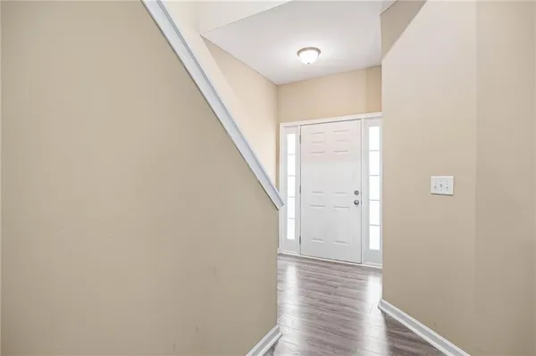 a view of a hallway with wooden floor and staircase