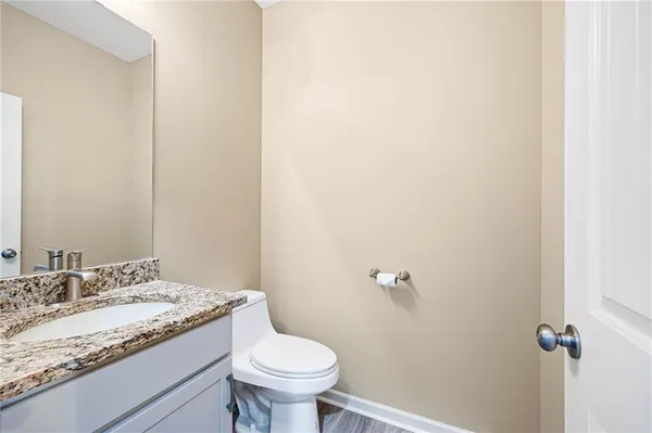 a bathroom with a granite countertop sink and a toilet