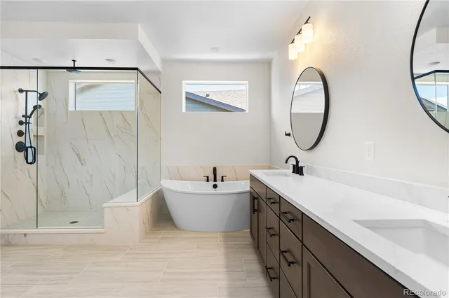 a bathroom with a double vanity sink mirror and bathtub