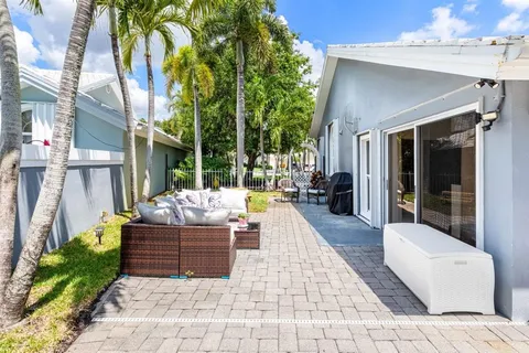 a view of a backyard with potted plants and large trees