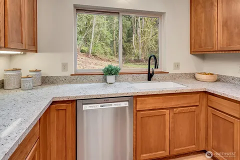 a kitchen with granite countertop cabinets sink and window