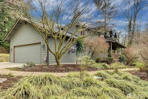 a backyard of a house with large trees and fence
