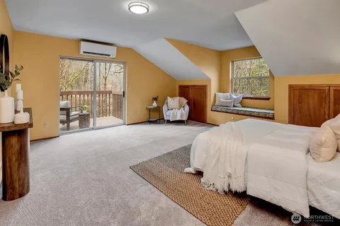 a bedroom with a bed and large windows