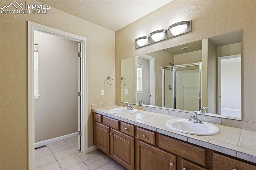 4058 Star View Colorado Springs, CO 80907 - Photo 25 of 41 a bathroom with a granite countertop sink and a mirror