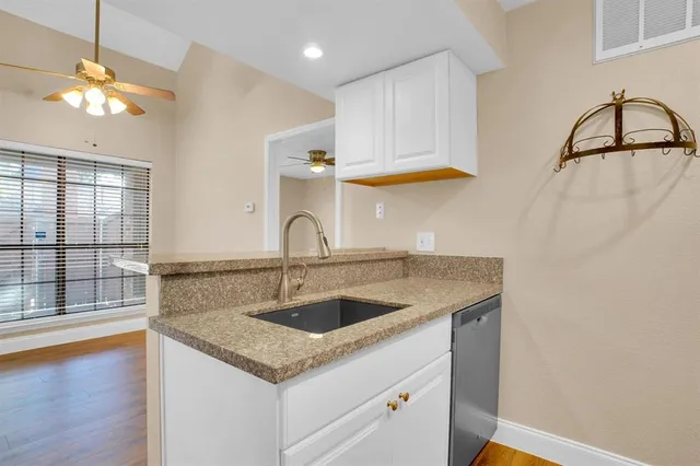 a kitchen with a refrigerator a stove top oven a sink and dishwasher with wooden floor