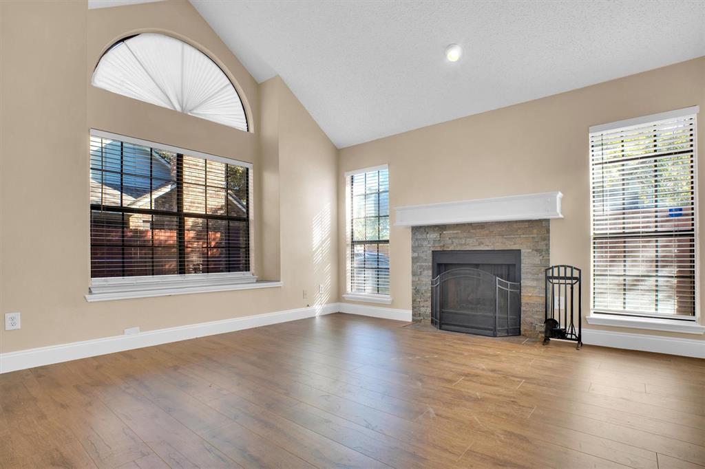 449 Harris Street, Unit I102 Coppell, TX 75019 - Photo 3 of 33 an empty room with wooden floor fireplace and windows