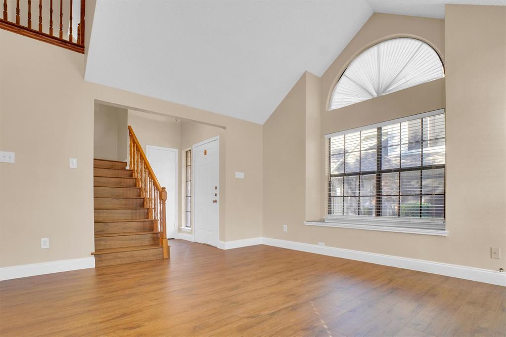 449 Harris Street, Unit I102 Coppell, TX 75019 - Photo 4 of 33 an empty room with wooden floor and windows