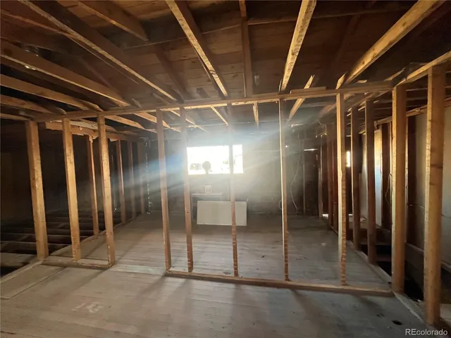 a view of an empty room with wooden floor and windows
