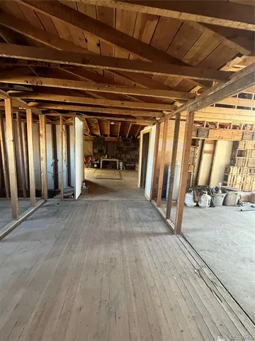 a view of a backyard with large trees and wooden fence
