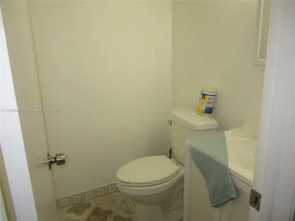 a white toilet sitting next to a bathroom sink and vanity