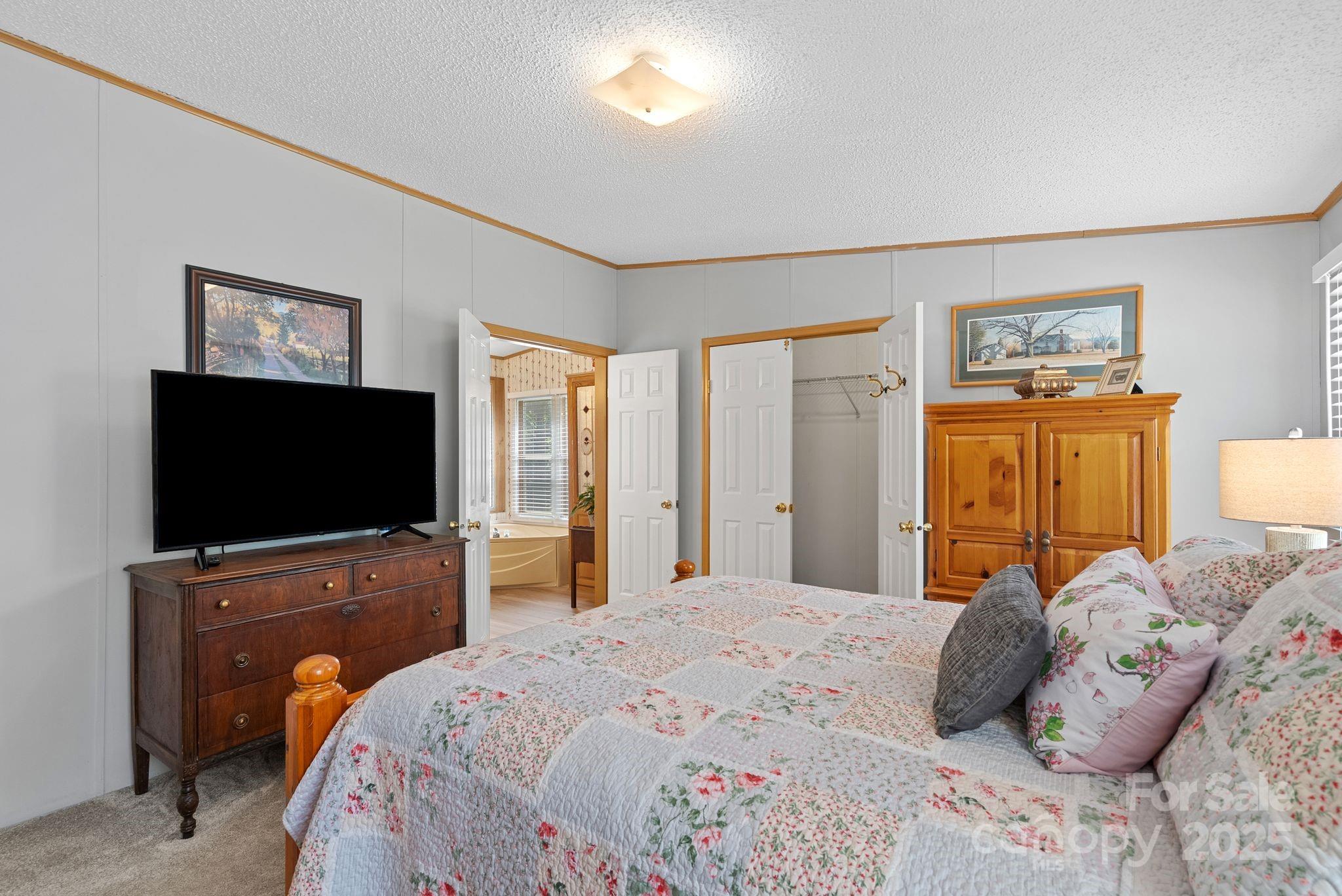 213 Old State 10 Road Black Mountain, NC 28711 - Photo 17 of 44 a bedroom with a bed and a flat screen tv