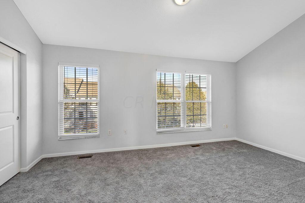 6345 Needletail Road, Unit 24634 Columbus, OH 43230 - Photo 22 of 58 • New gray carpet ~ 2021 • Gray painted walls • Vaulted ceiling • Ceiling light • Full wall closet with double sliding doors • 2” blinds