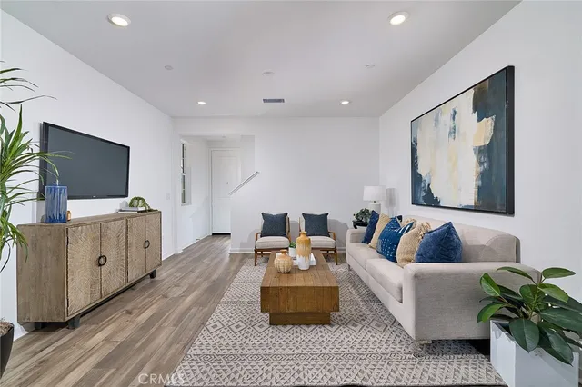 a living room with furniture potted plant and a wooden floor