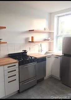 a kitchen with cabinets appliances and a window