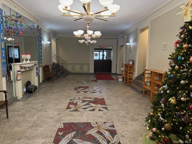 118-14 83rd Avenue, Unit 3G Queens, NY 11415 - Photo 11 of 12 Foyer featuring stairs, ornamental molding, and a chandelier