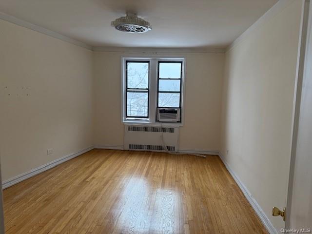 118-14 83rd Avenue, Unit 3G Queens, NY 11415 - Photo 6 of 12 Unfurnished room featuring light wood-type flooring, crown molding, and radiator