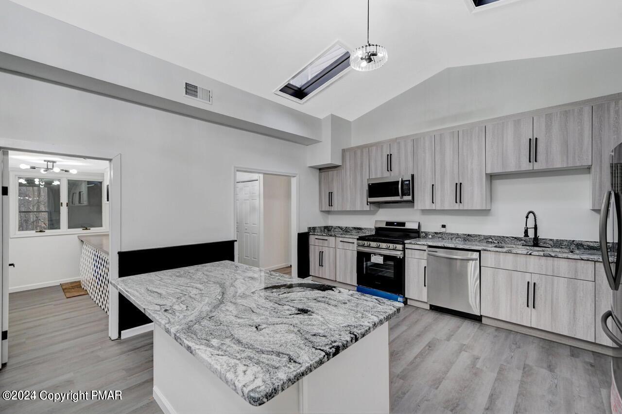 113 Java Hill East Stroudsburg, PA 18302 - Photo 4 of 36 a kitchen with stainless steel appliances granite countertop a stove top oven a sink and dishwasher a refrigerator with wooden floor