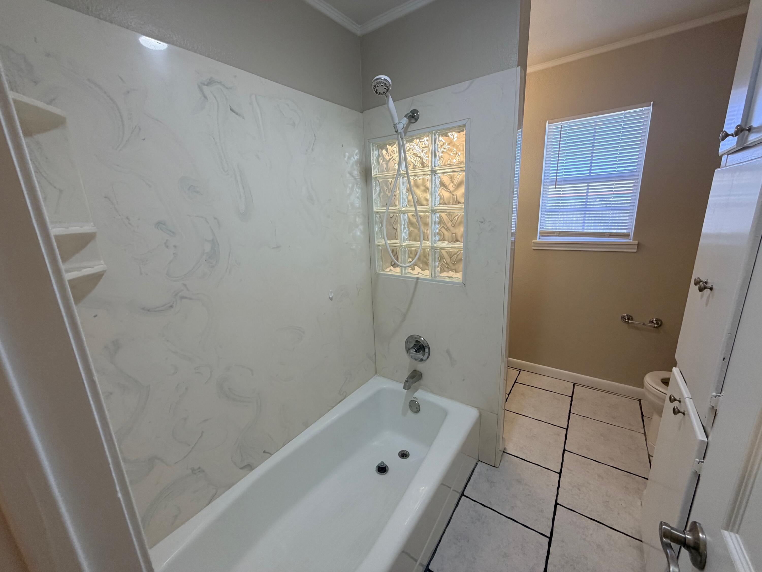 4310 42nd Street Lubbock, TX 79413 - Photo 11 of 25 a bathroom with a bathtub and a shower