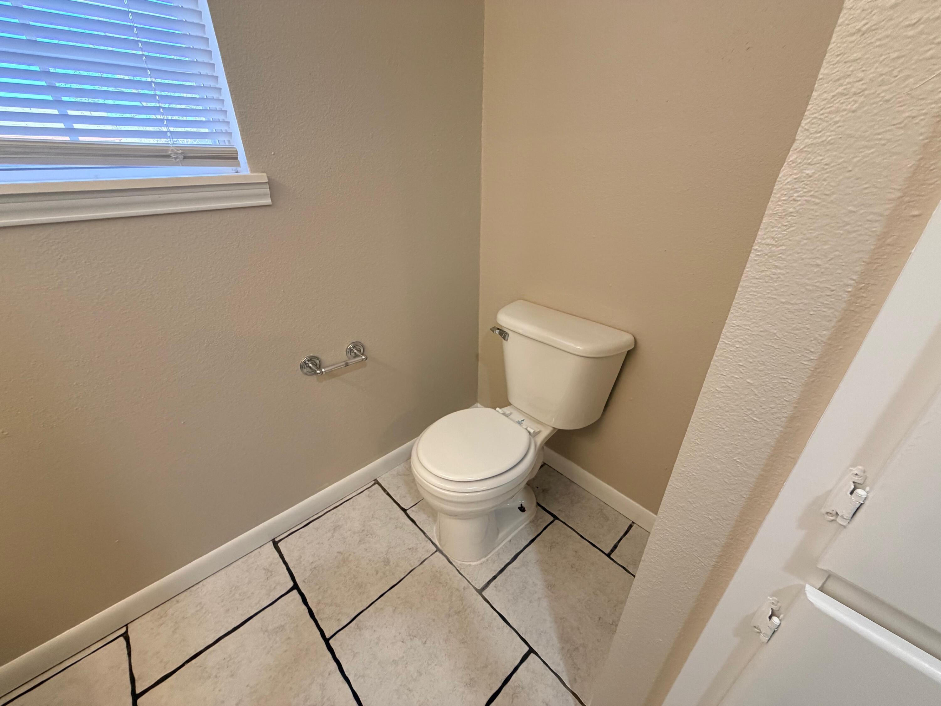 4310 42nd Street Lubbock, TX 79413 - Photo 13 of 25 a white toilet sitting next to a white cabinet
