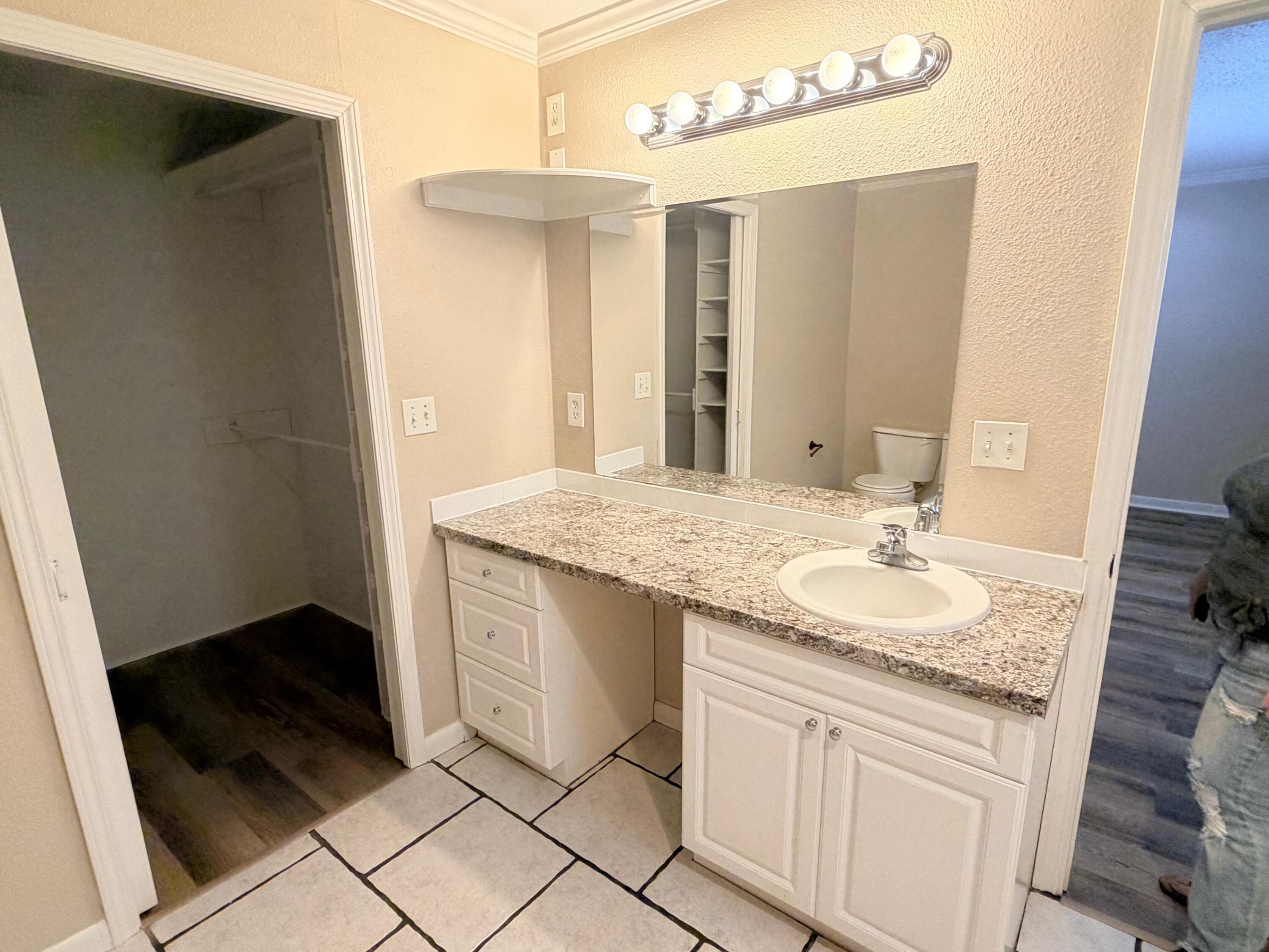 4310 42nd Street Lubbock, TX 79413 - Photo 20 of 25 a bathroom with a granite countertop sink and a mirror
