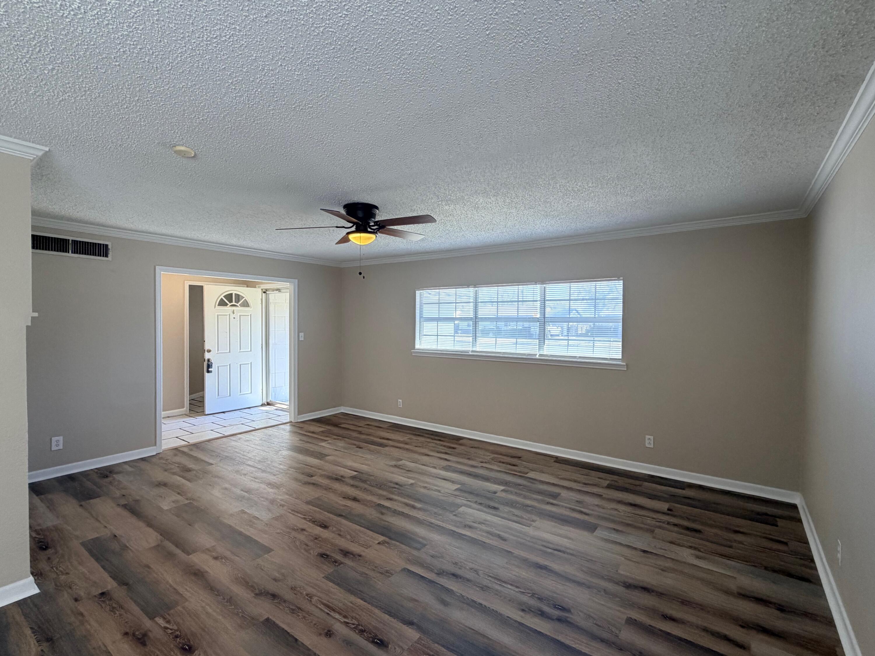 4310 42nd Street Lubbock, TX 79413 - Photo 2 of 25 a view of an empty room with wooden floor and a window