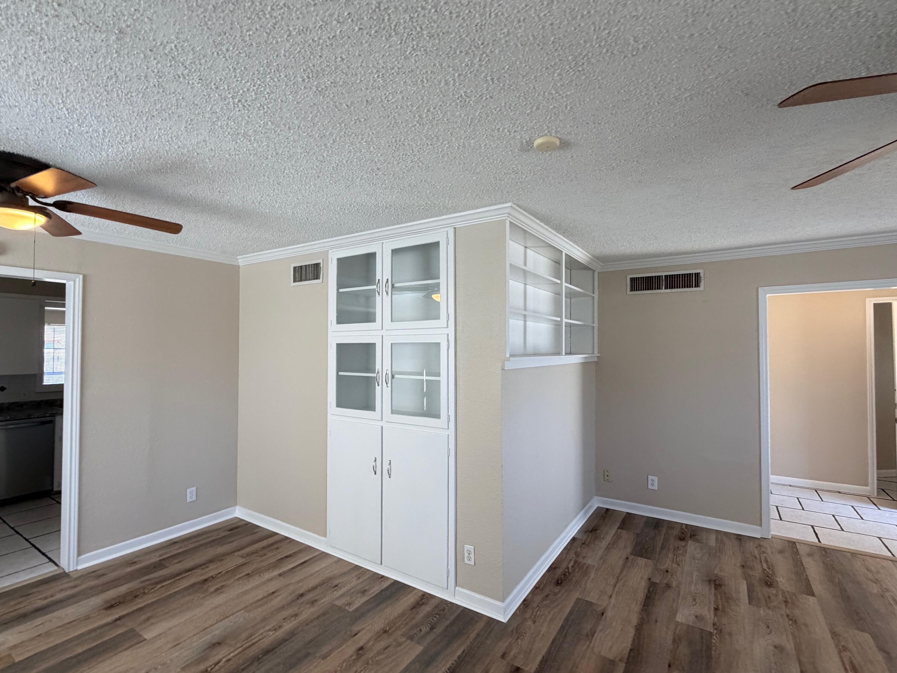 4310 42nd Street Lubbock, TX 79413 - Photo 4 of 25 a view of an empty room with wooden floor and a window