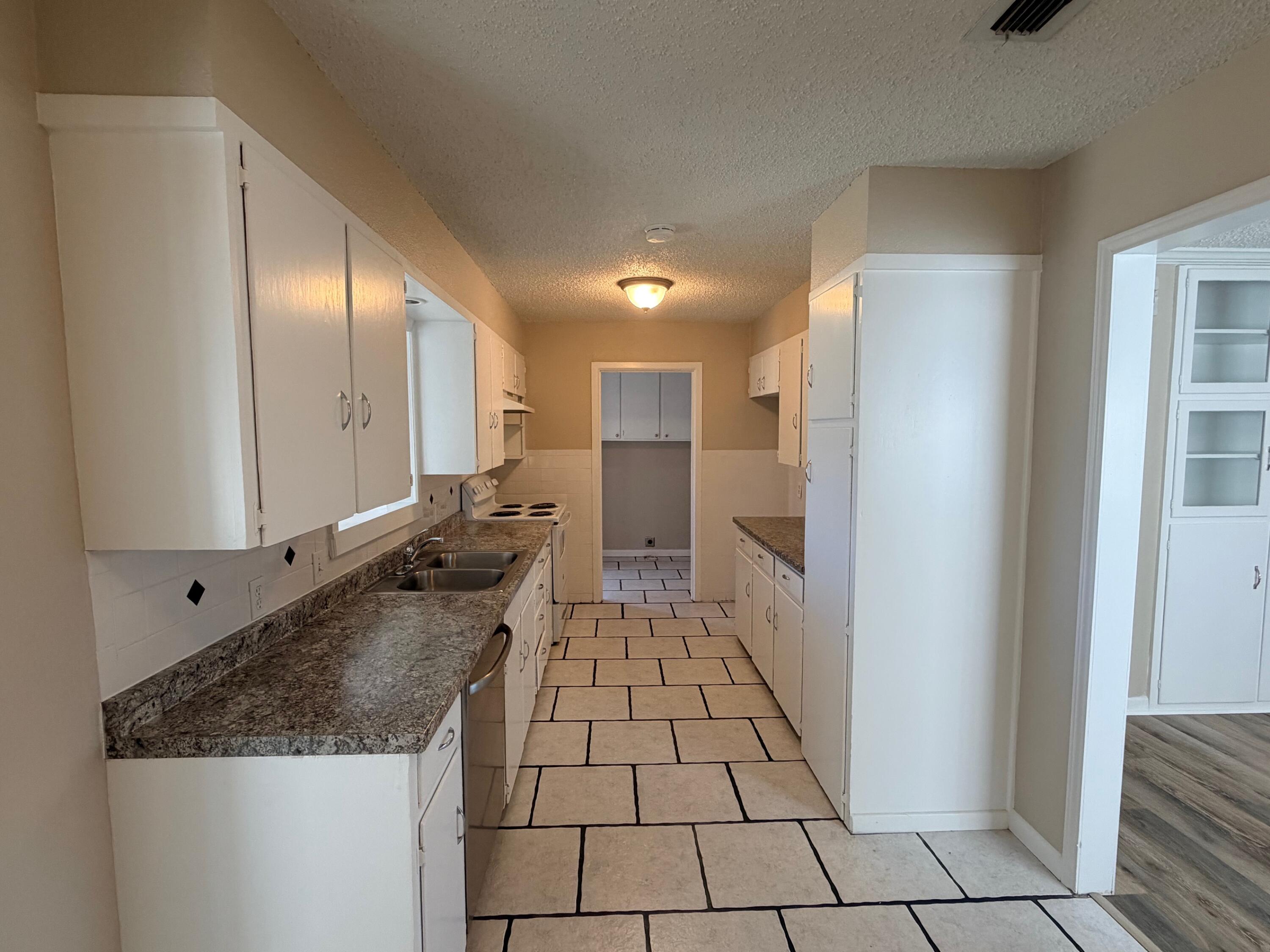 4310 42nd Street Lubbock, TX 79413 - Photo 6 of 25 a bathroom with a granite countertop sink and a mirror