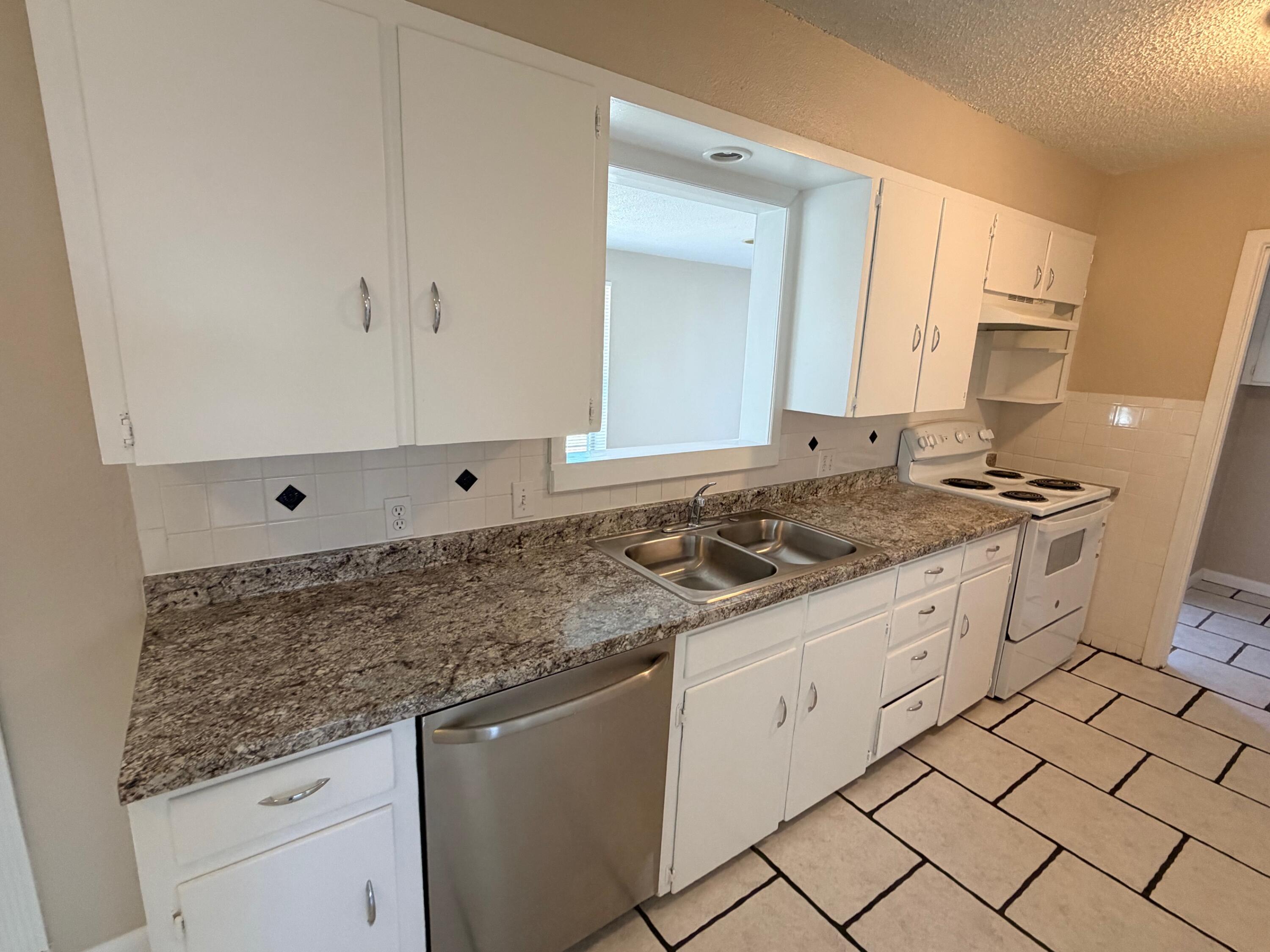 4310 42nd Street Lubbock, TX 79413 - Photo 7 of 25 a kitchen with granite countertop white cabinets and white appliances