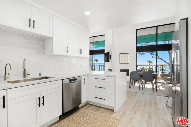a kitchen with white cabinets and sink